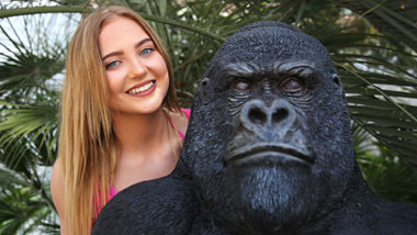 Girl posing with gorilla statue