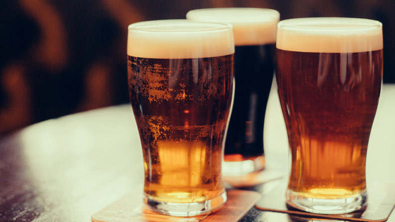 three beers sitting on wooden table